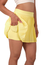 Yellow pleated skirt worn by a person on a white background